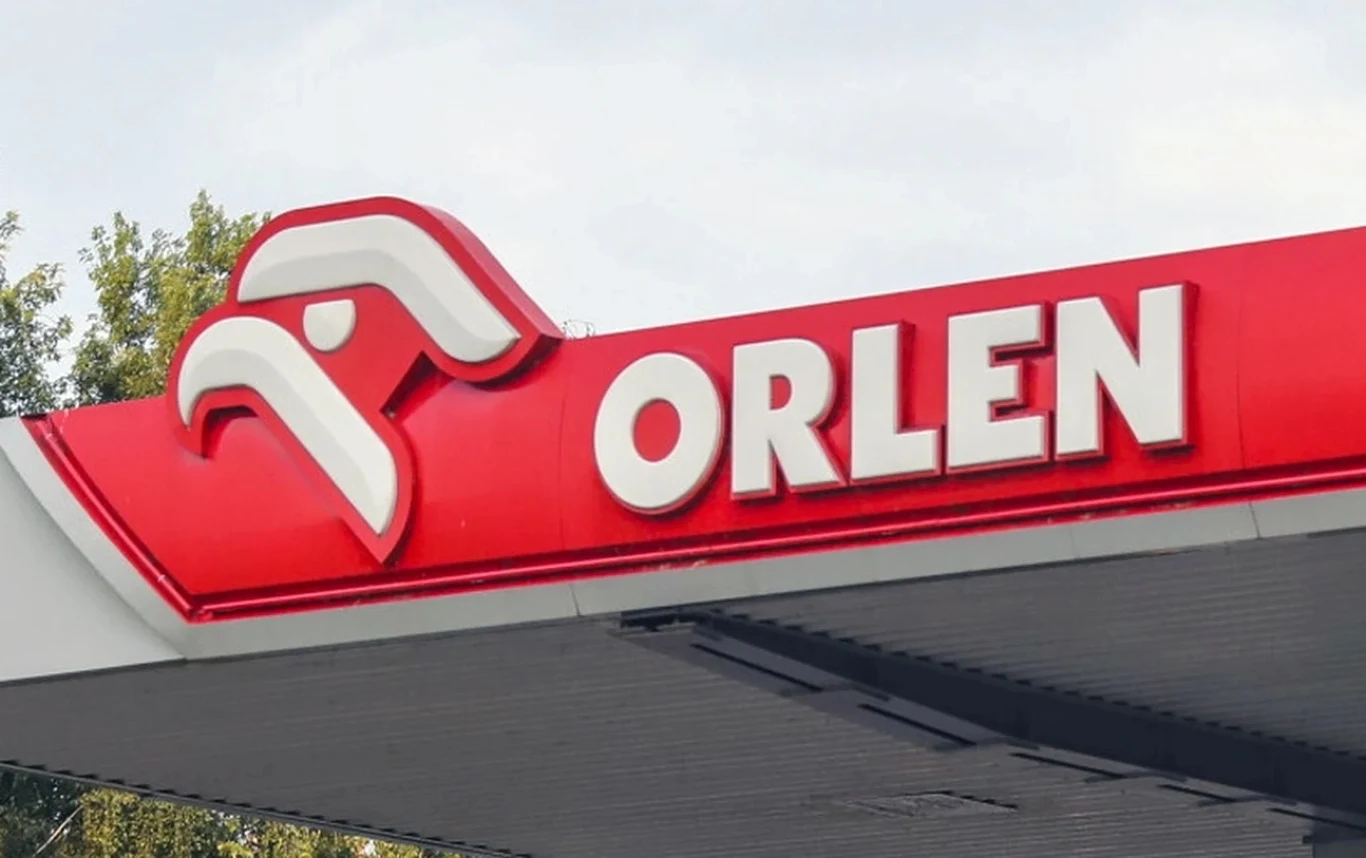 Orlen wyraźnie obniżył hurtowe ceny oleju napędowego Czerwono-biały szyld stacji Orlen z logo i napisem na tle jasnego nieba oraz drzewa w górze kadru