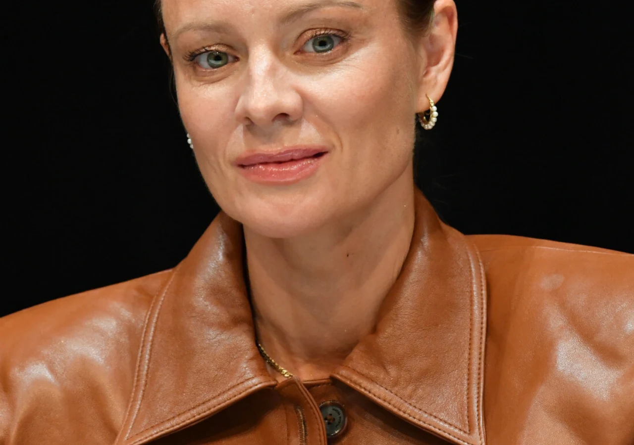 Magdalena Boczarska Magdalena Boczarska w brązowej, skórzanej kurtce, ze spiętymi włosami i złotymi kolczykami na ciemnym tle