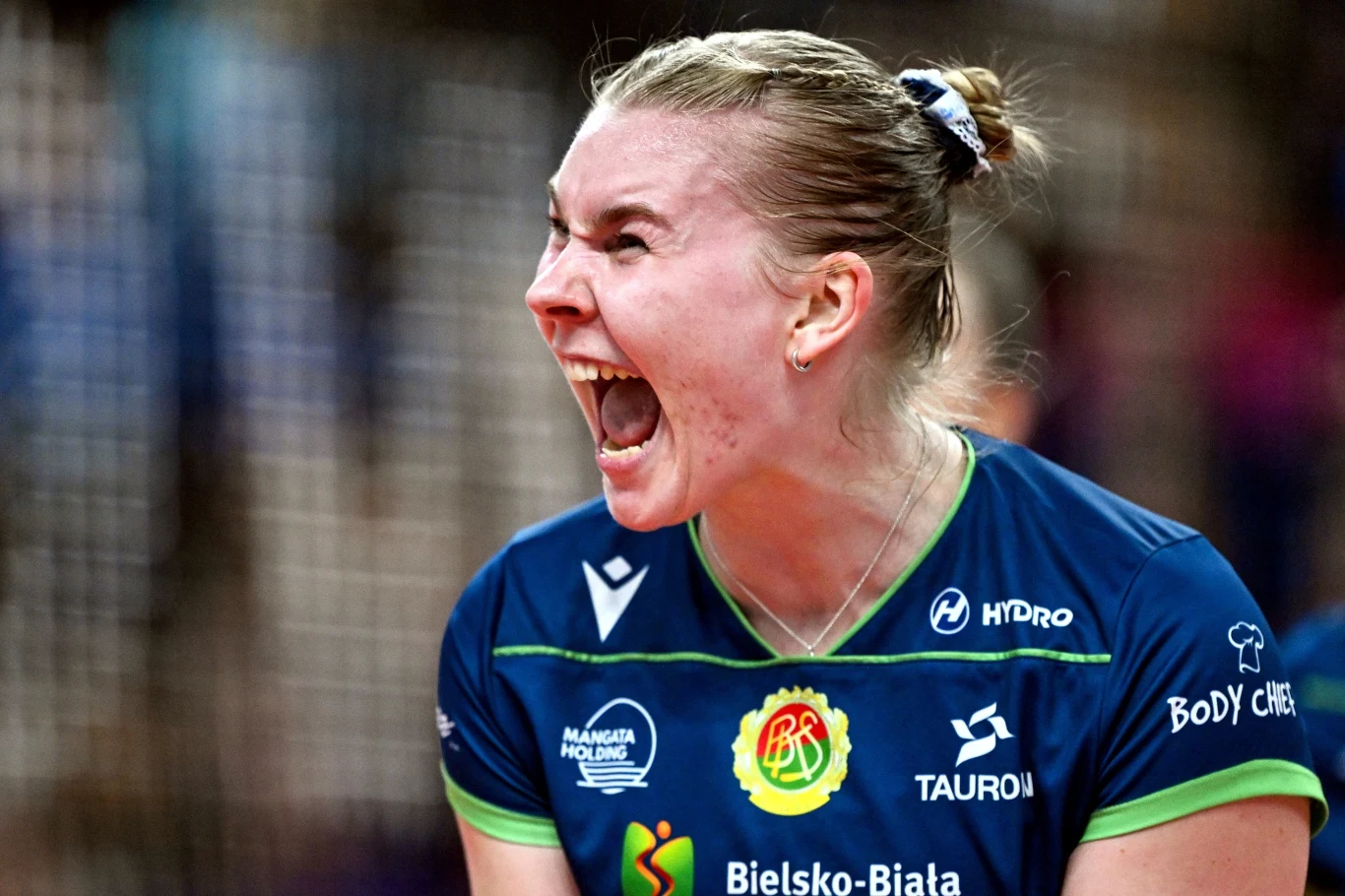 zawodniczka siatkarska w koszulce Bielsko-Biała z wyrazem intensywnych emocji na twarzy, otwartymi ustami i spiętymi włosami, wyrażająca ogromną determinację podczas gry