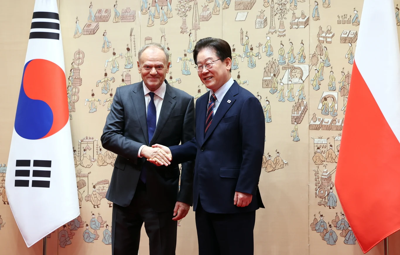Premier Donald Tusk i prezydent Korei Południowej Li Dze Mjung Premier Donald Tusk i prezydent Li Dze Mjung podają sobie ręce na tle flag Polski i Korei Południowej.