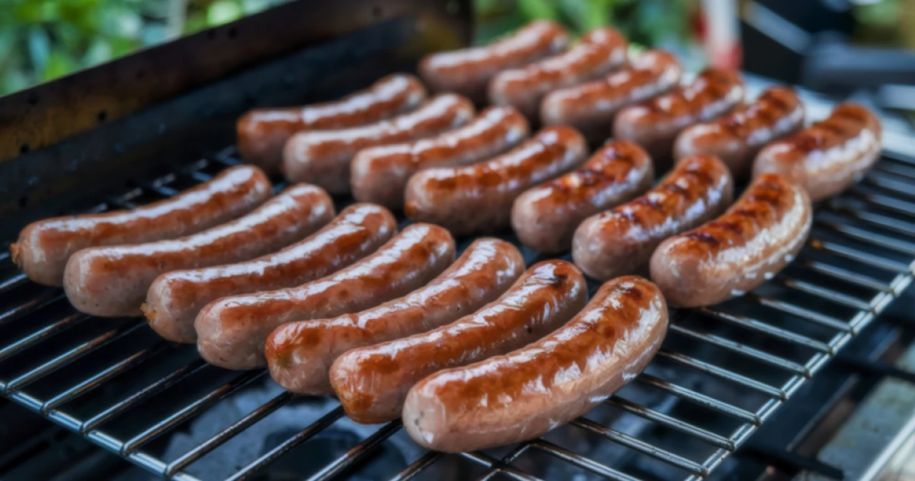 Ukryta promocja Auchan. Ruszyła wyprzedaż grillów na majówkę Kiełbaski grillowane na metalowym ruszcie, równomiernie przypieczone, z brązową i błyszczącą skórką.