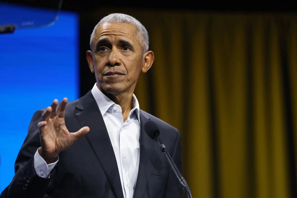 Były prezydent USA Barack Obama porównał węgierskie wybory do polskich Barack Obama w ciemnym garniturze przy mównicy, gestykuluje na tle niebiesko-żółtej scenografii