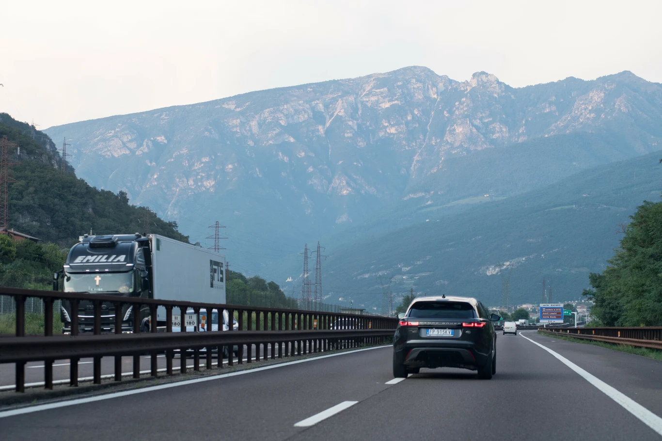 Zakaz zjazdu z autostrady w Tyrolu - przepisy i mandaty 2026. Autostrada w Tyrolu wśród gór, samochód i ciężarówka mijają się na tle zielonych masywów.