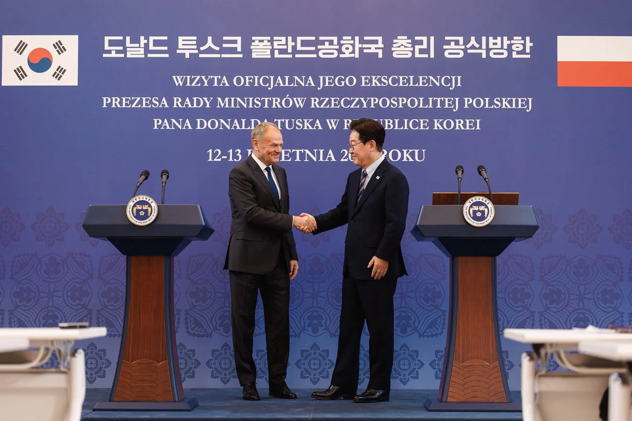 Seul, Korea Południowa, 13.04.2026. Premier Donald Tusk (L) i prezydent Republiki Korei Południowej Lee Jae Myung (P) Premier Donald Tusk i prezydent Lee Jae Myung ściskają dłonie na tle flag Polski i Korei Południowej.