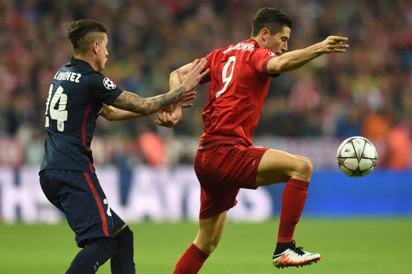 Robert Lewandowski w trakcie drugiego starcia Bayernu Monachium z Atletico Madryt w półfinale Ligi Mistrzów 15/16 Robert Lewandowski kontrolujący piłkę podczas meczu Bayernu z Atletico, obok zawodnik rywali w granatowym stroju