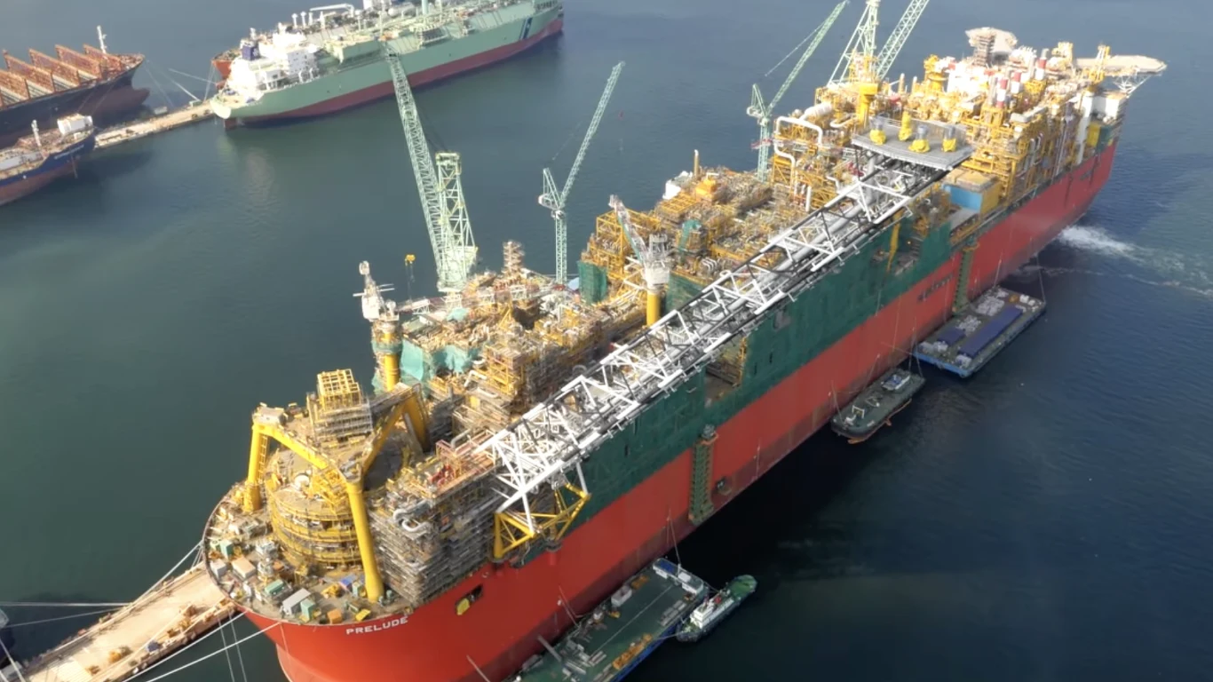 Największa jednostka pływająca świata została zbudowana w stoczni Samsung Heavy Industries w południowokoreańskim Geoje. Ogromna jednostka pływająca typu FPSO z intensywnie zabudowaną powierzchnią pokładu, pełna instalacji technicznych i maszyn, cumuje w stoczni przy kilku mniejszych jednostkach serwisowych; w tle widoczne dwa duże statki przy brzegu oraz dźwigi portowe.