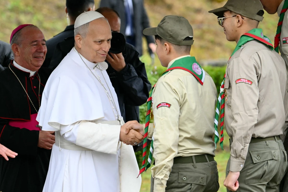 Papież Leon XIV podczas wizyty w Algierii Papież Leon XIV, obok harcerze w mundurze i duchowny
