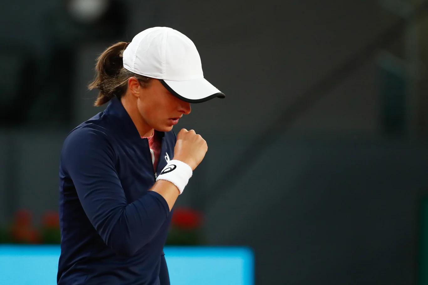 Iga Świątek w II rundzie turnieju WTA w Madrycie w 2021 roku pokonała Laurę Siegemund Iga Świątek w granatowej bluzie i białej czapce na korcie tenisowym podczas meczu z Laurą Siegemund w Madrycie 2021.