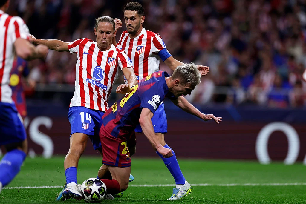 Marcos Llorente, Dani Olmo Dani Olmo z Barcelony walczy o piłkę z dwoma piłkarzami Atlético Madryt podczas meczu Ligi Mistrzów.