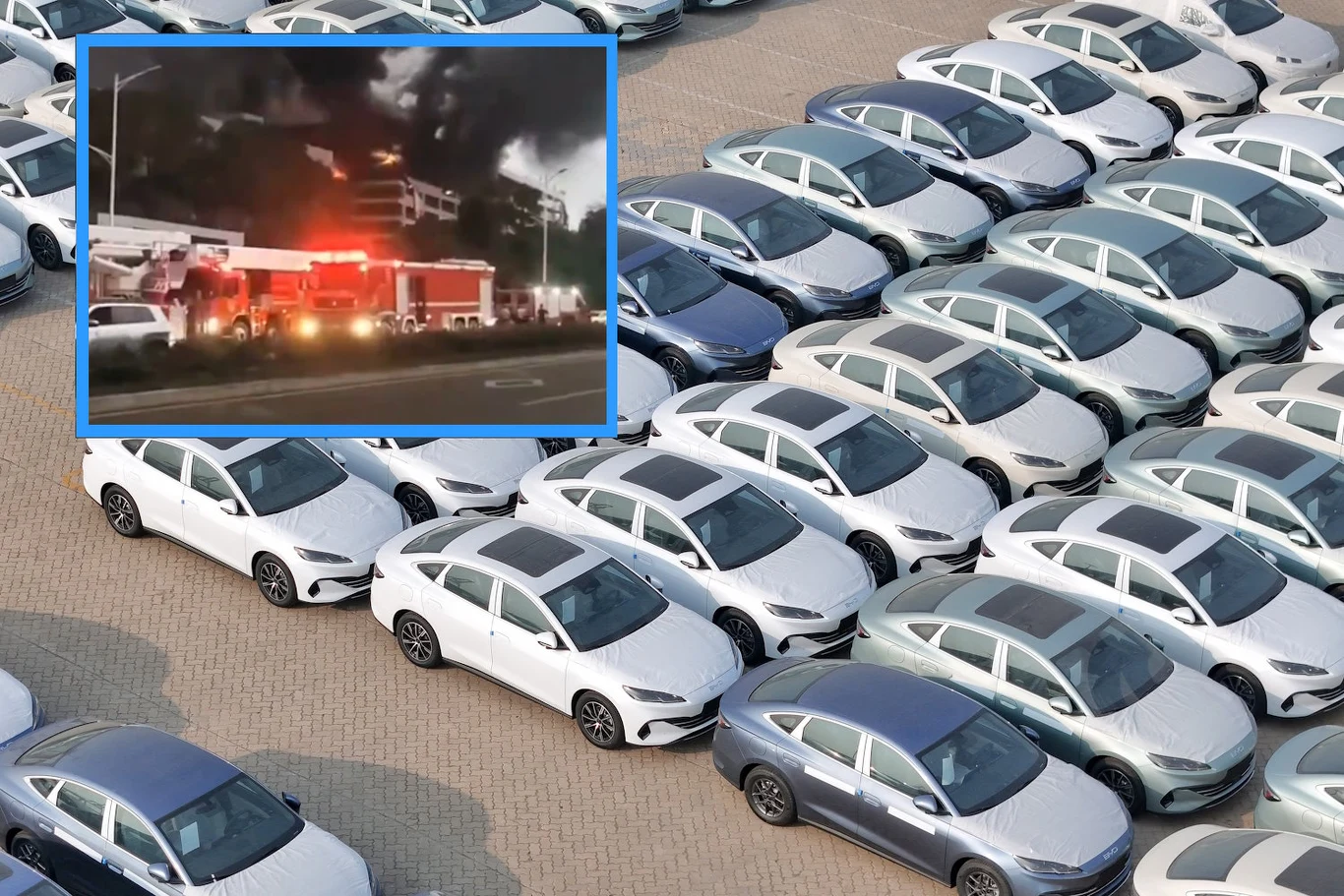 Pożar samochodów elektrycznych na parkingu BYD w Shenzhen /fot AFP/x.com Rzędy srebrnych i białych aut elektrycznych na parkingu BYD, wstawka ze strażakami i dymem podczas pożaru.