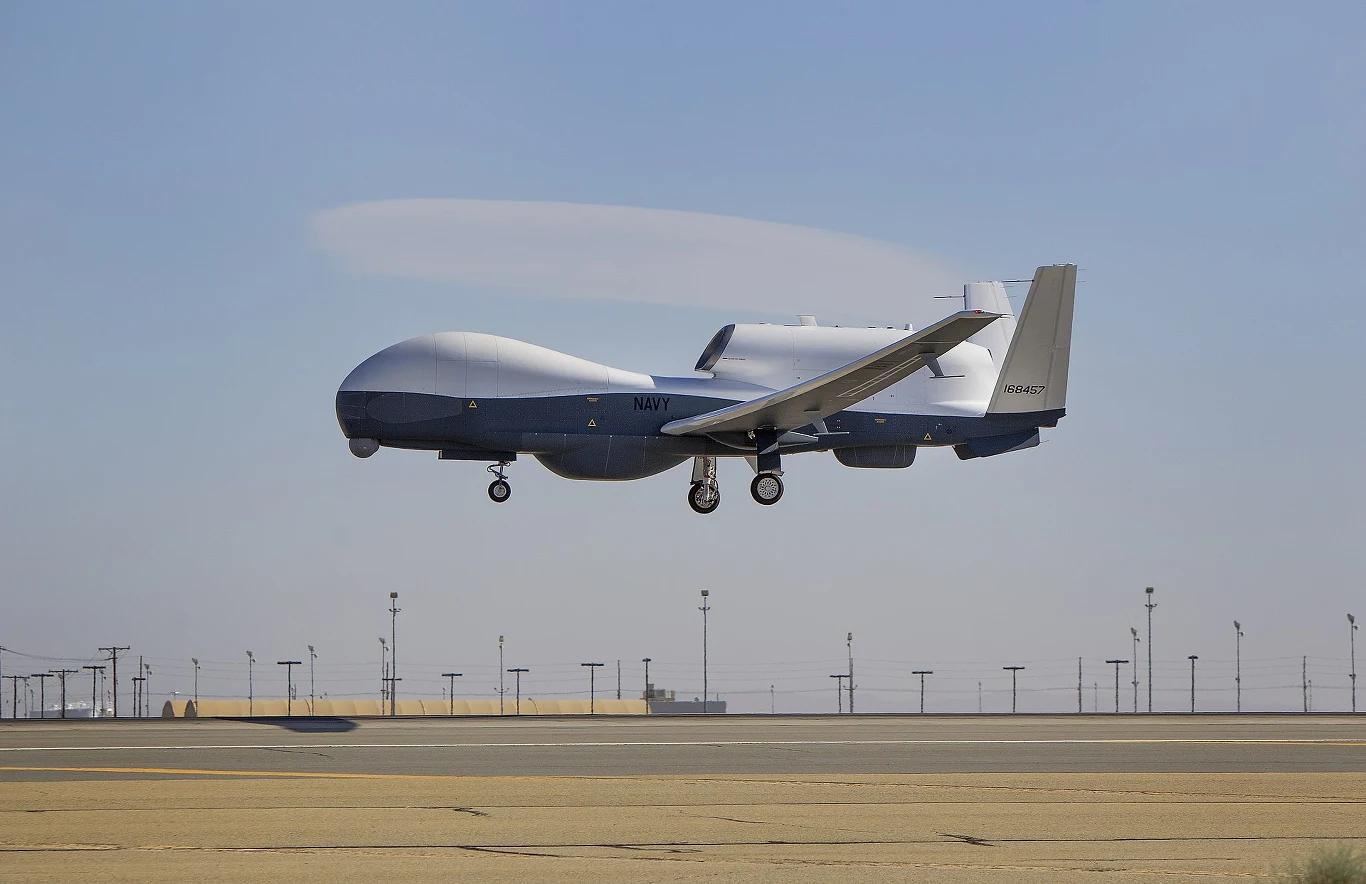 Amerykanie przyznali się do utraty potężnego drona, który szpiegował Irańczyków Wielki dron MQ-4C Triton podczas startu z wysuniętym podwoziem; w tle infrastruktura wojskowego lotniska oraz błękitne niebo