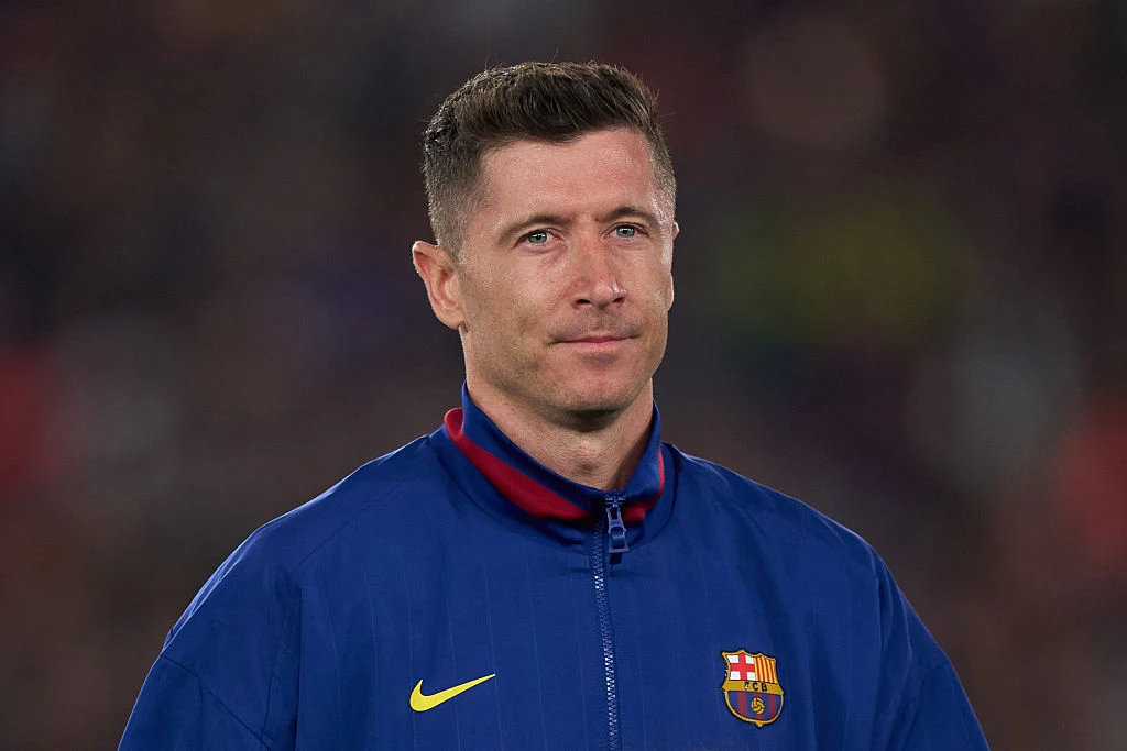 Robert Lewandowski Robert Lewandowski w niebieskiej kurtce FC Barcelona z logo Nike, na tle rozmytego stadionu.