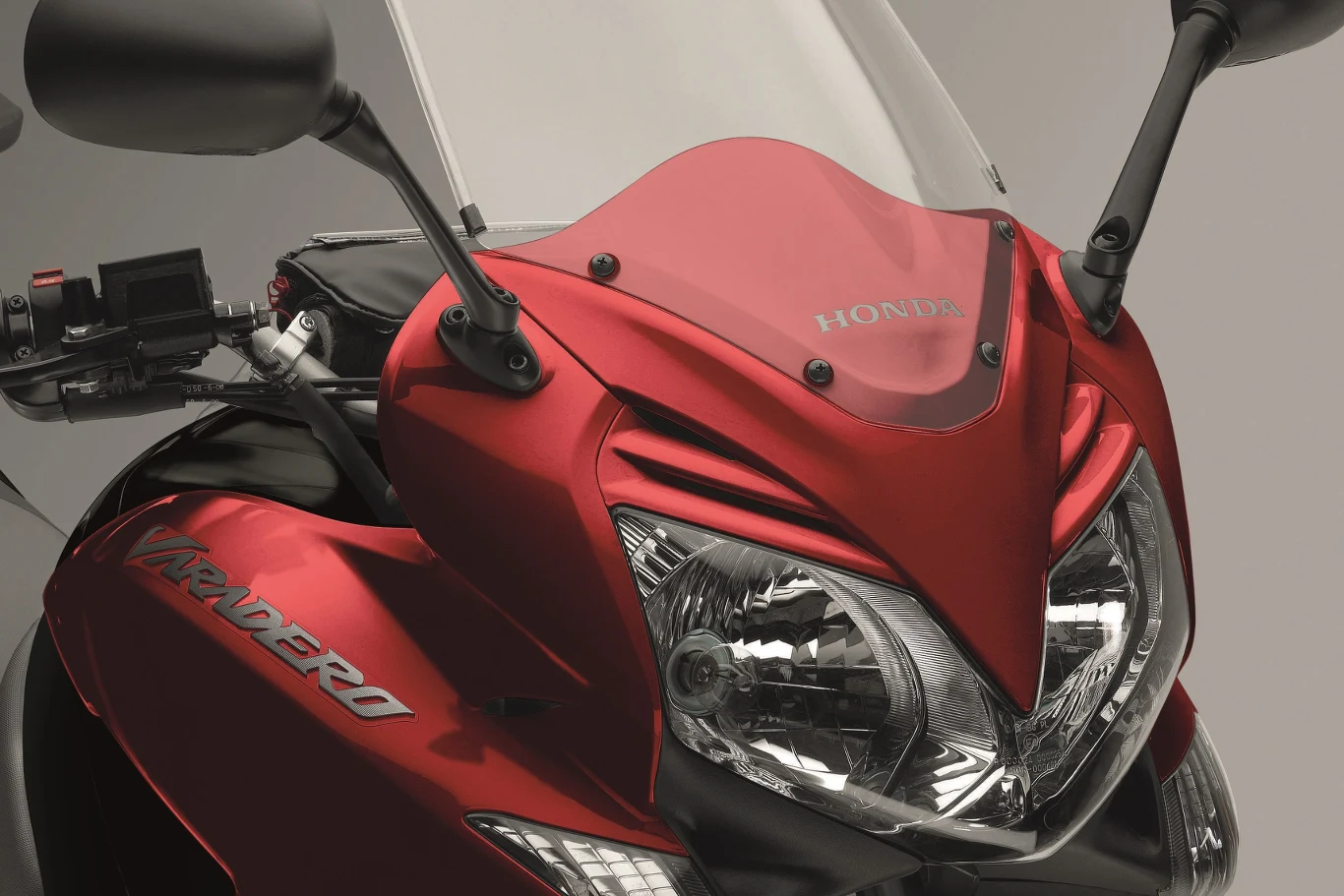 Jakie są największe motocykle 125? Oto 5 propozycji. Czerwony motocykl Honda 125, przód z dwoma reflektorami, szybą i logo na sportowej owiewce