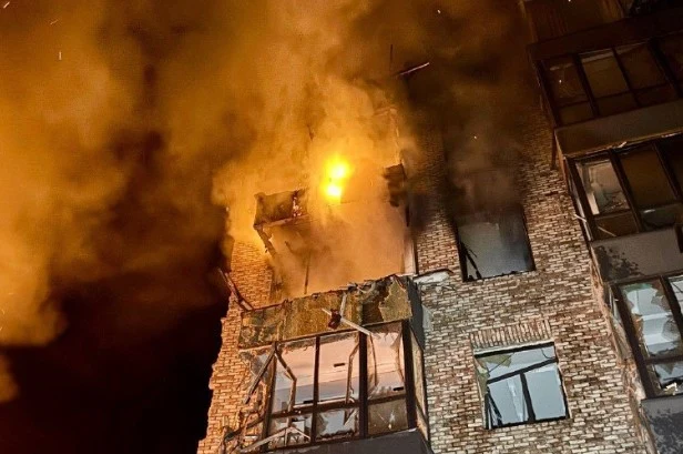 W nocy ze środy na czwartek Rosja przeprowadziła zmasowane ataki na Ukrainę Płomienie i dym wydobywają się przez okna górnych pięter ceglanej kamienicy po nocnym ataku na Ukrainę.