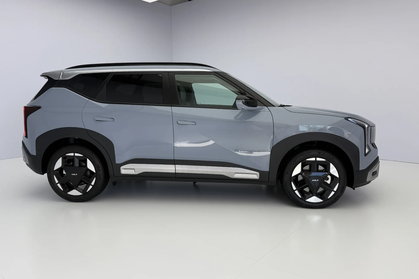 srebrny SUV z ciemnymi szybami, nowoczesnym designem karoserii, wyrazistymi, kanciastymi liniami oraz dużymi, efektownymi felgami na tle jasnego, minimalistycznego pomieszczenia