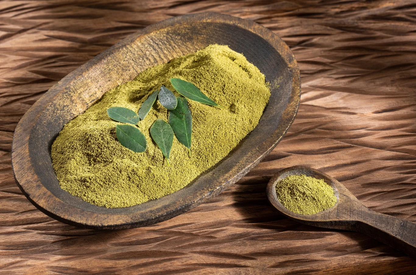 Wygląda jak matcha, ale lepiej smakuje. Super food, który wykorzystasz w wielu przepisach Zielony proszek z moringi w miseczce obok świeżych liści. To naturalny superfood do koktajli i sosów