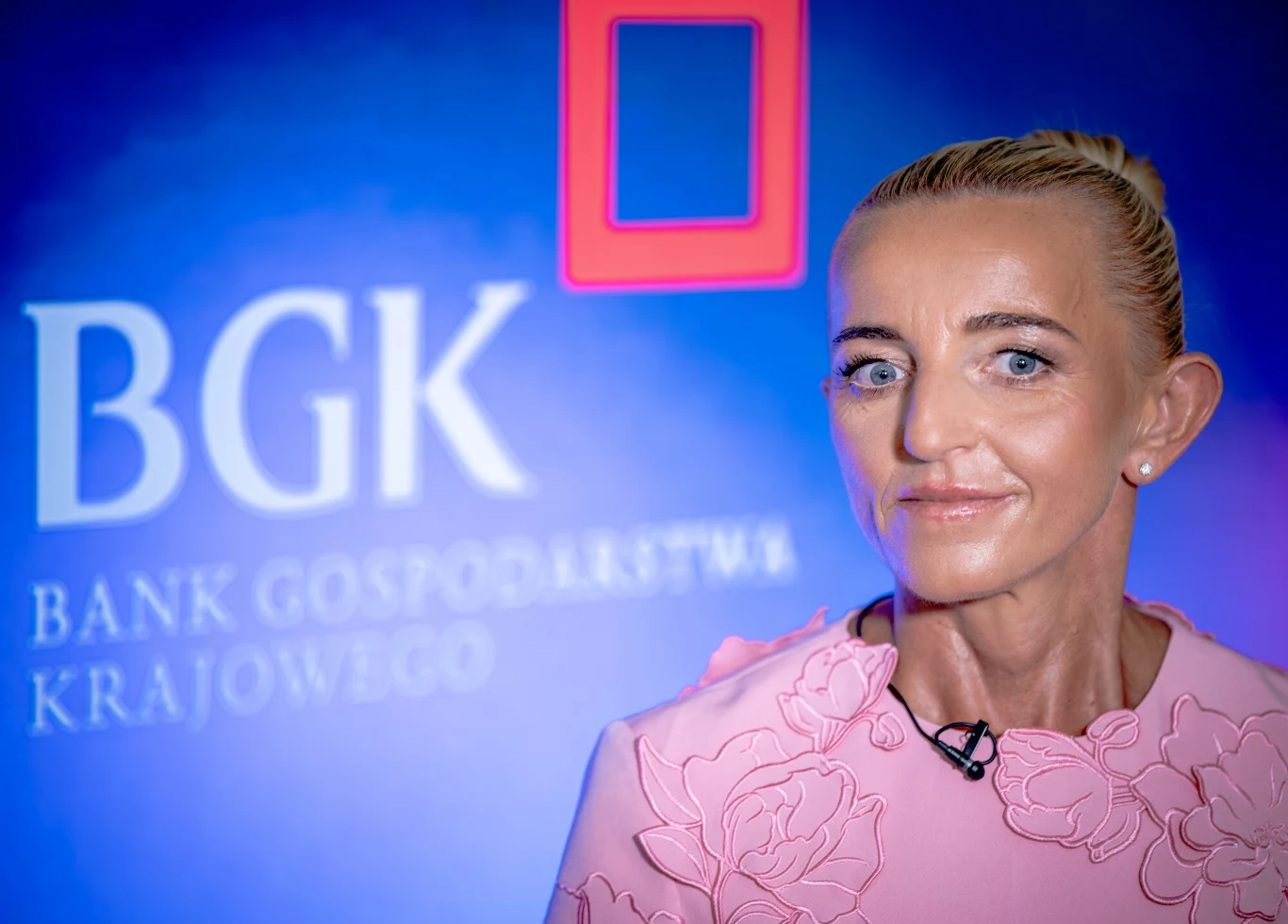 Wiceprezes BGK prof. Marta Postuła ogłosiła program gwarancji kredytowych w zakupach obronnych Wiceprezes BGK prof. Marta Postuła w różowej sukience na tle ścianki z logo BGK podczas ogłoszenia programu gwarancji