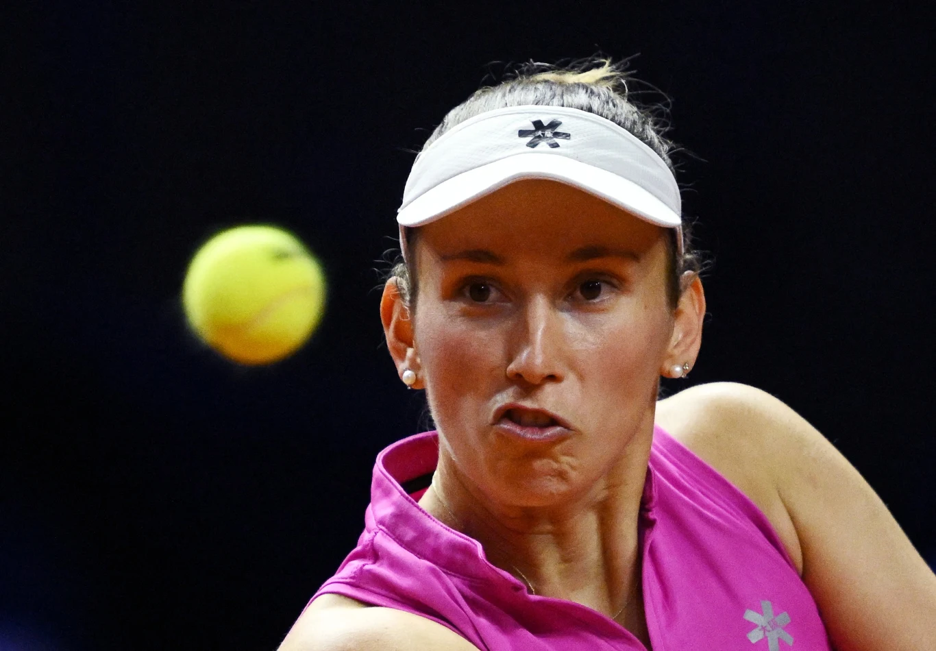 Elise Mertens, Stuttgart 2026 zawodniczka tenisowa w różowym stroju sportowym skupiona na odbiciu piłki, dynamiczny moment gry z piłką tenisową w locie przed jej twarzą