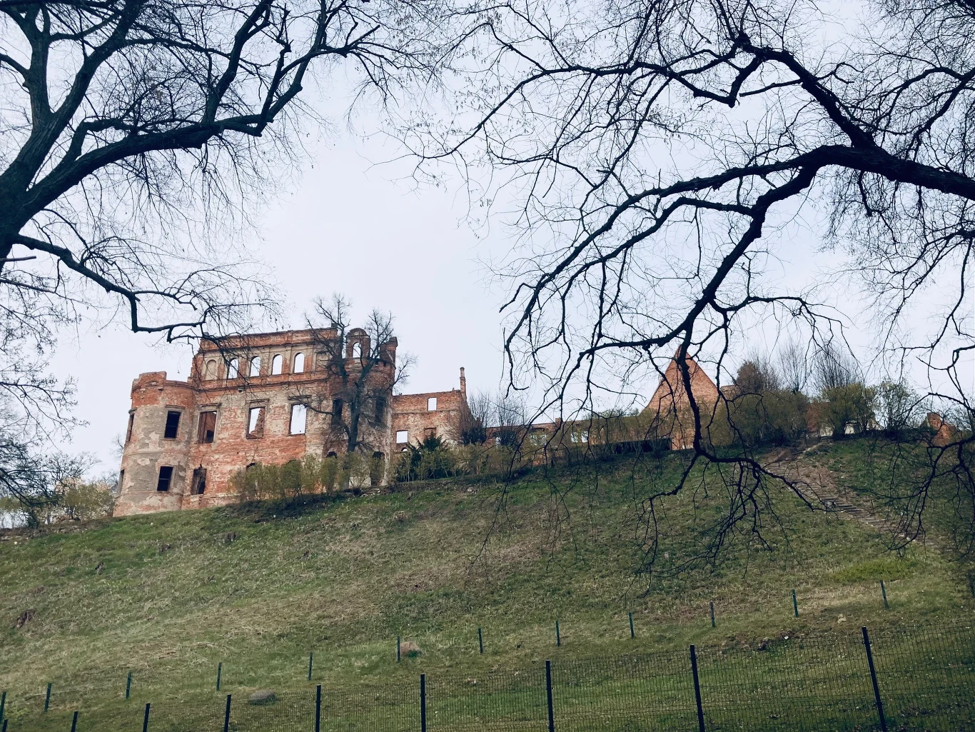 Zamek Karolat spowity jest aurą tajemniczości, a lokalsi znają wiele legend dotyczących tego historycznego miejsca ruiny ceglanego zamku na wzgórzu, otoczone bezlistnymi drzewami oraz ogrodzeniem u podnóża wzniesienia