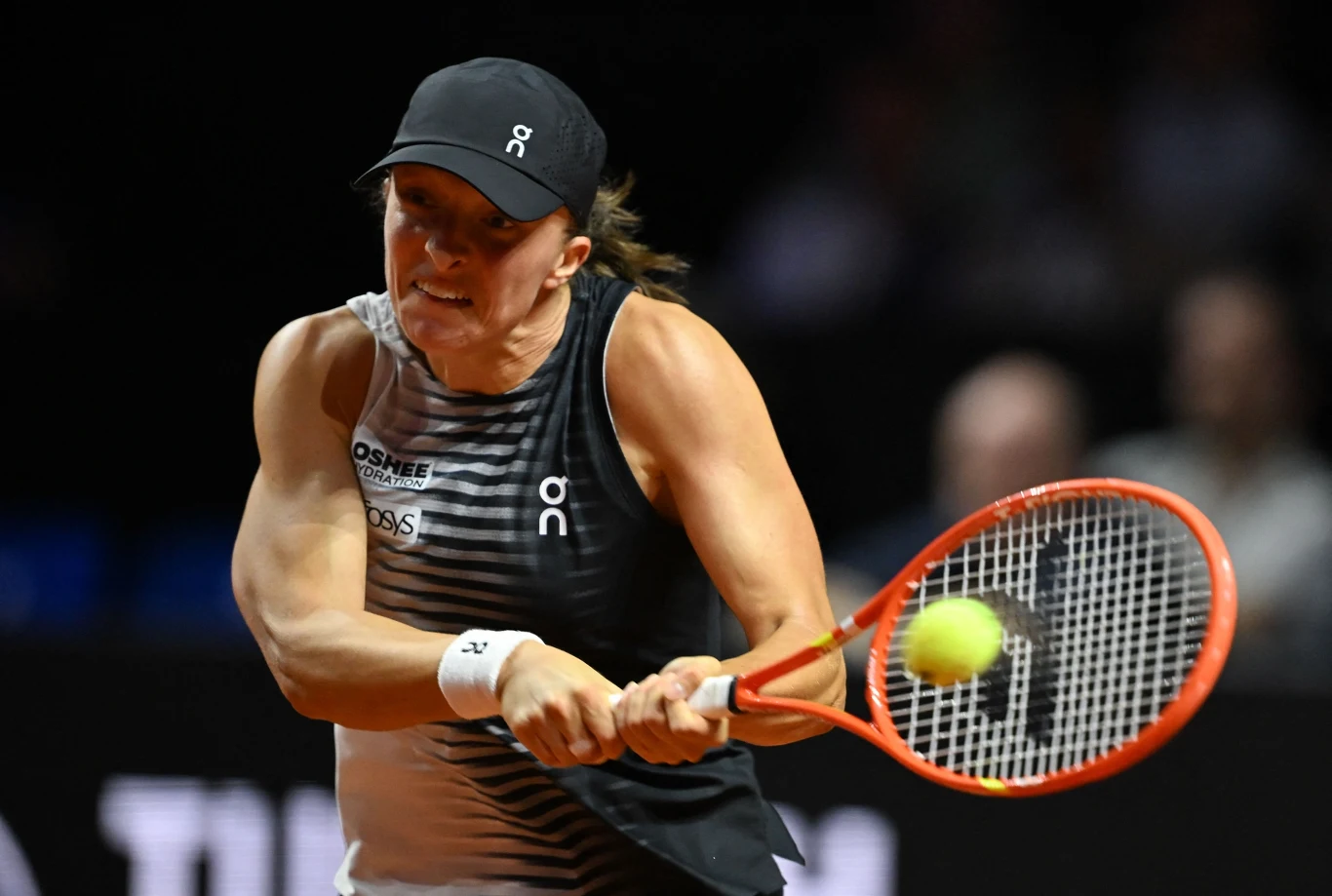 tenisistka w czarnej czapce i sportowej koszulce dynamicznie odbija piłkę rakietą, skupiona na intensywnym pojedynku na korcie