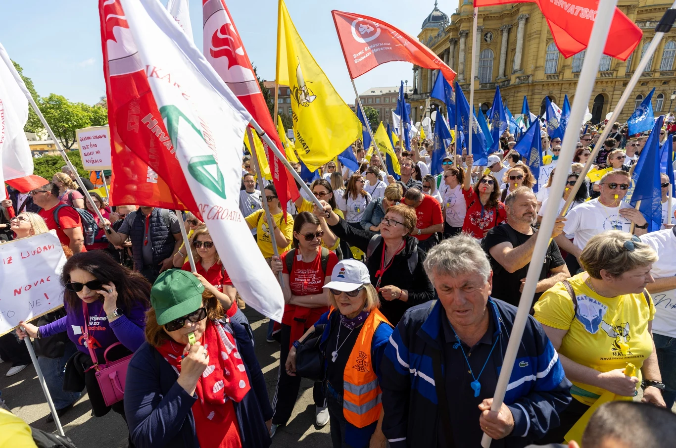 Protesty w Chorwacji. Domagają się wyższych płac i emerytur Tłum podczas protestu w Chorwacji, widoczne flagi, transparenty i symbole poparcia dla sprawy