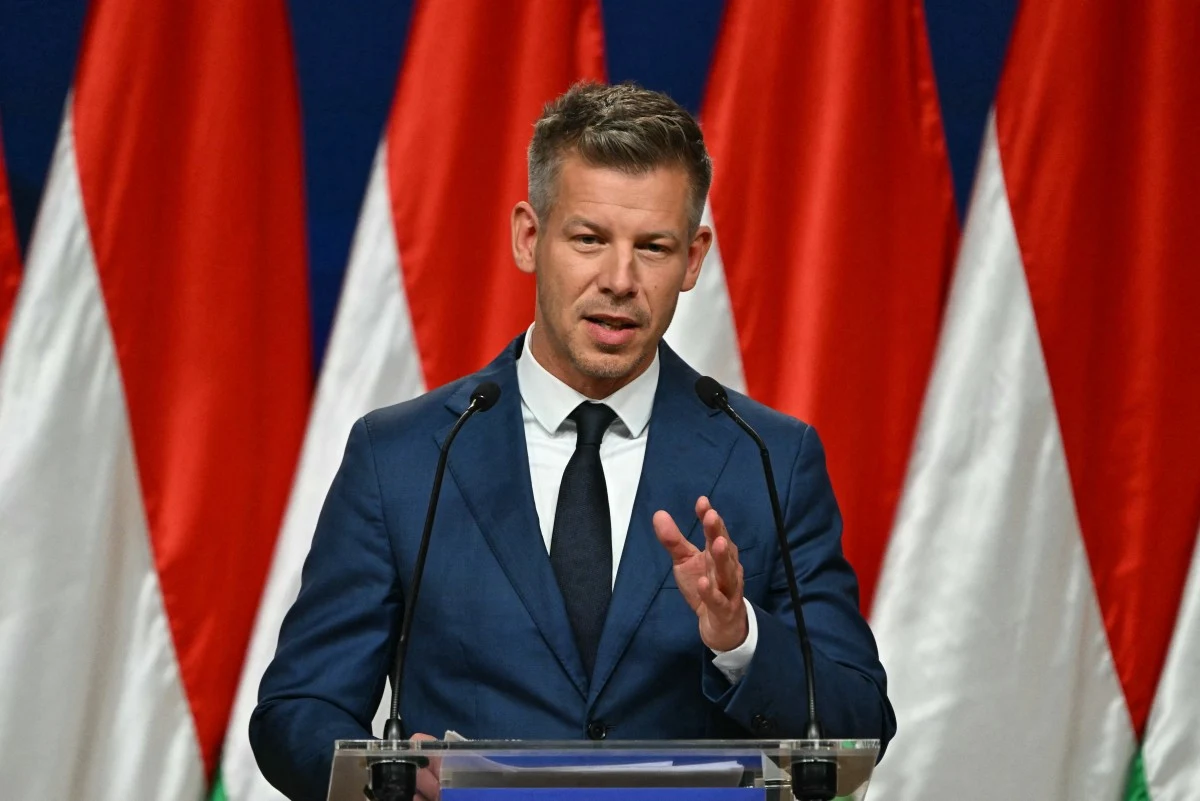 Partia TISZA pod wodzą Petera Magyara zwiększa swoją przewagę po przeliczeniu głosów z zagranicy Peter Magyar w garniturze przy mównicy na tle węgierskich flag.