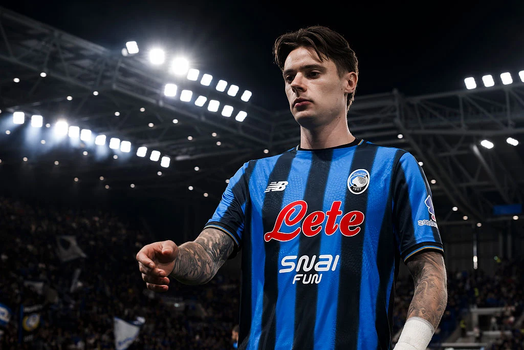 Nicola Zalewski Nicola Zalewski w niebiesko-czarnej koszulce, z tatuażami na przedramionach, na tle stadionu Serie A
