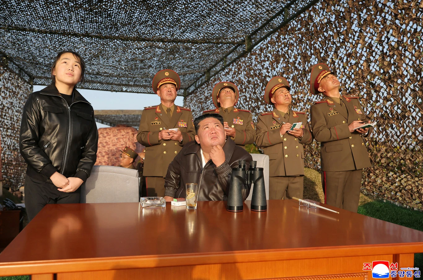 Kim Dzong Un podczas testów rakiet balistycznych. Przyglądała im się również jego córka Na pierwszym planie Kim Dzong Un obserwujący testy rakiet balistycznych. Wokół niego zgromadzeni są generałowie i jego córka.