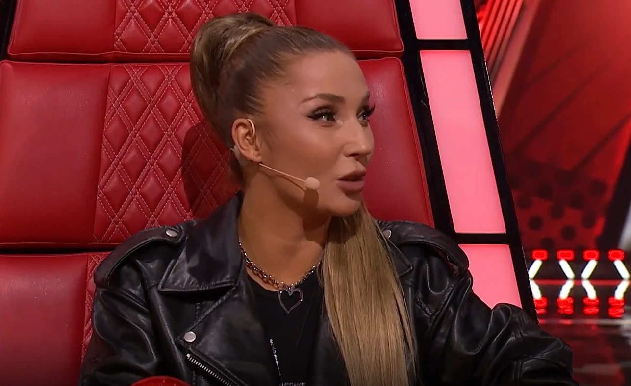 Cleo w "The Voice Kids" wybrała trójkę najlepszych ze swojej drużyny Cleo z wysokim kucykiem na czerwonym fotelu w czarnej skórzanej kurtce, z mikrofonem przy twarzy, na planie "The Voice Kids"
