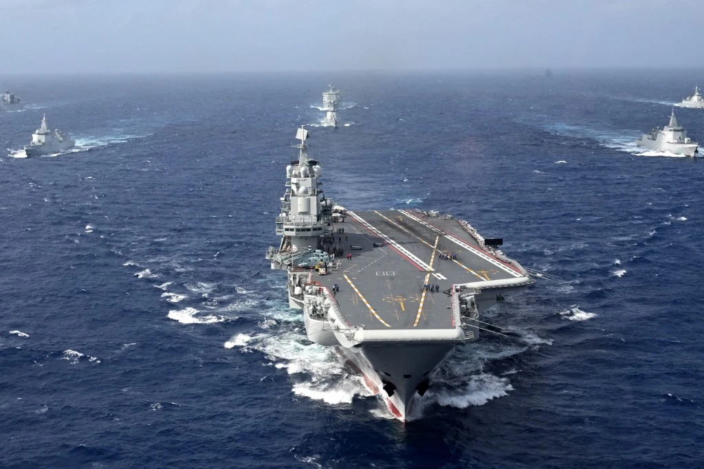 Chiński lotniskowiec Liaoning wraz z grupą towarzyszących mu okrętów Chiński lotniskowiec Liaoning na otwartym morzu, eskortowany przez kilka okrętów wojennych