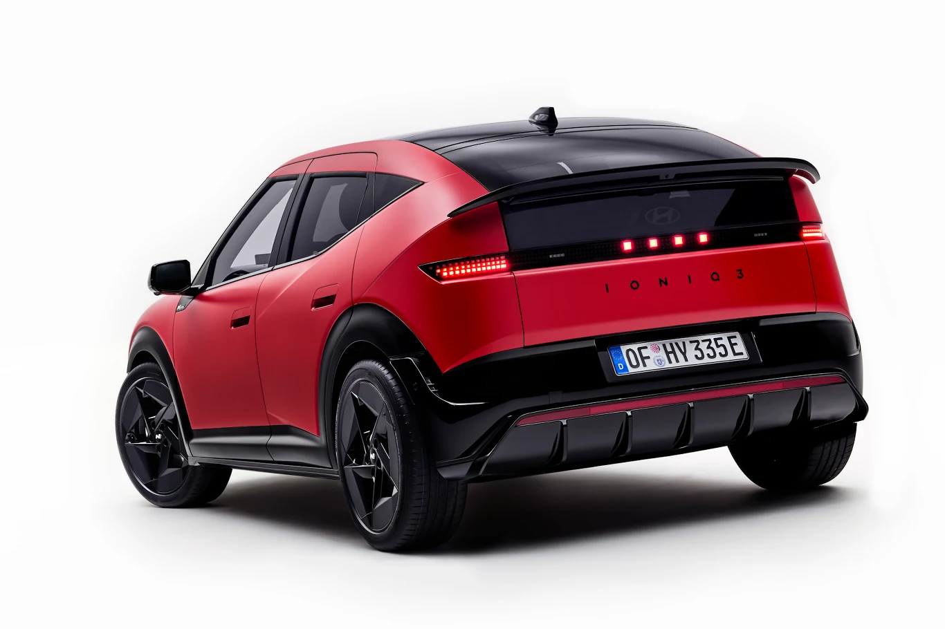 Ioniq 3 z tyłu wygląda bardzo charakterystycznie Czerwono-czarny samochód elektryczny typu SUV z nowoczesnym, dynamicznym designem, wyrazistym oświetleniem LED z tyłu i napisem 'IONIQ 5' na klapie bagażnika.