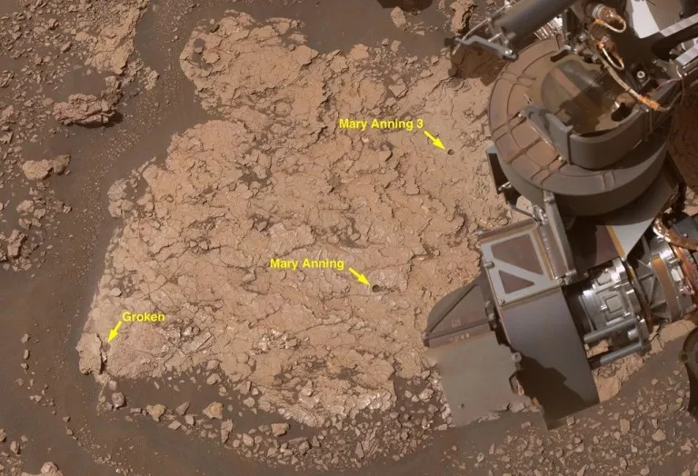 Trzy otwory, które łazik Curiosity NASA wywiercił w skałach marsjańskich w miejscu o nazwie "Mary Anning" w październiku 2020 r. Cegiełki życia znaleziono w "Mary Anning 3". Powierzchnia skalista Marsa z wyraźnie oznaczonymi punktami badawczymi: „Mary Anning”, „Mary Anning 3” i „Groken”, widoczna część sprzętu badawczego łazika na prawo od centrum kadru.