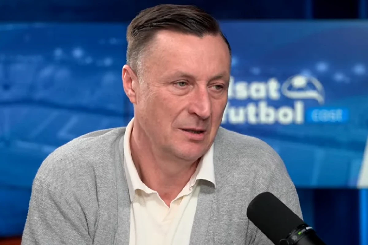 Tomasz Hajto Tomasz Hajto w szarej marynarce i białej koszuli mówi do mikrofonu w studiu Polsat Futbol