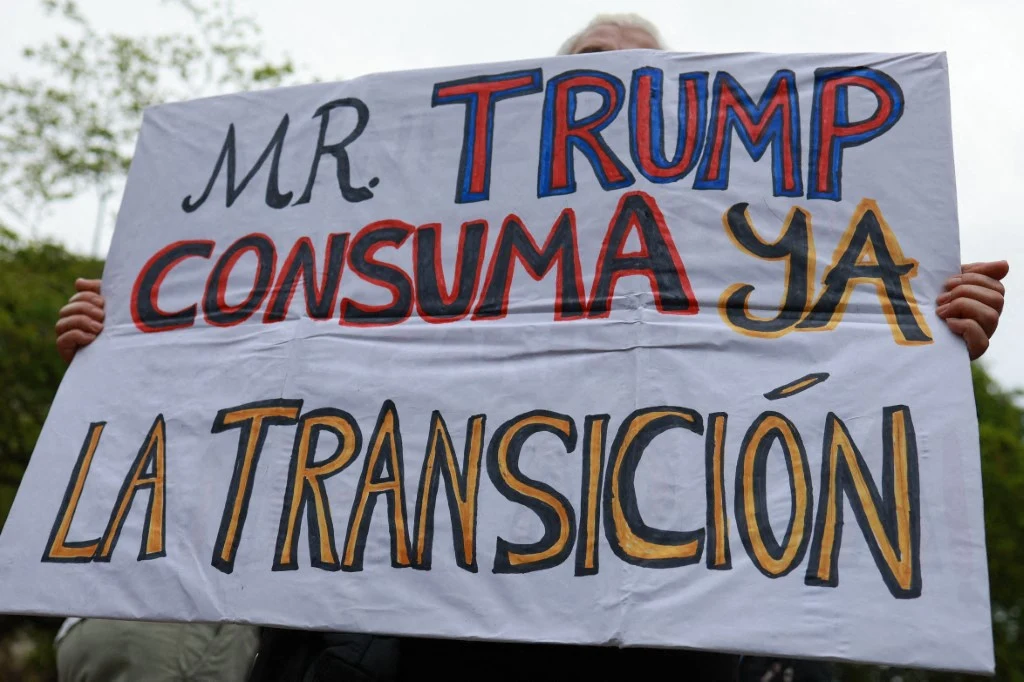 Protest przeciwko niskim zarobkom w Caracas, 16 kwietnia 2026 r. Jeden z uczestników trzyma transparent z napisem: "Panie Trump, proszę dokończyć proces transformacji" Protest przeciwko niskim zarobkom w Caracas, 16 kwietnia 2026 r. Jeden z uczestników trzyma transparent z napisem: "Panie Trump, proszę dokończyć proces transformacji"