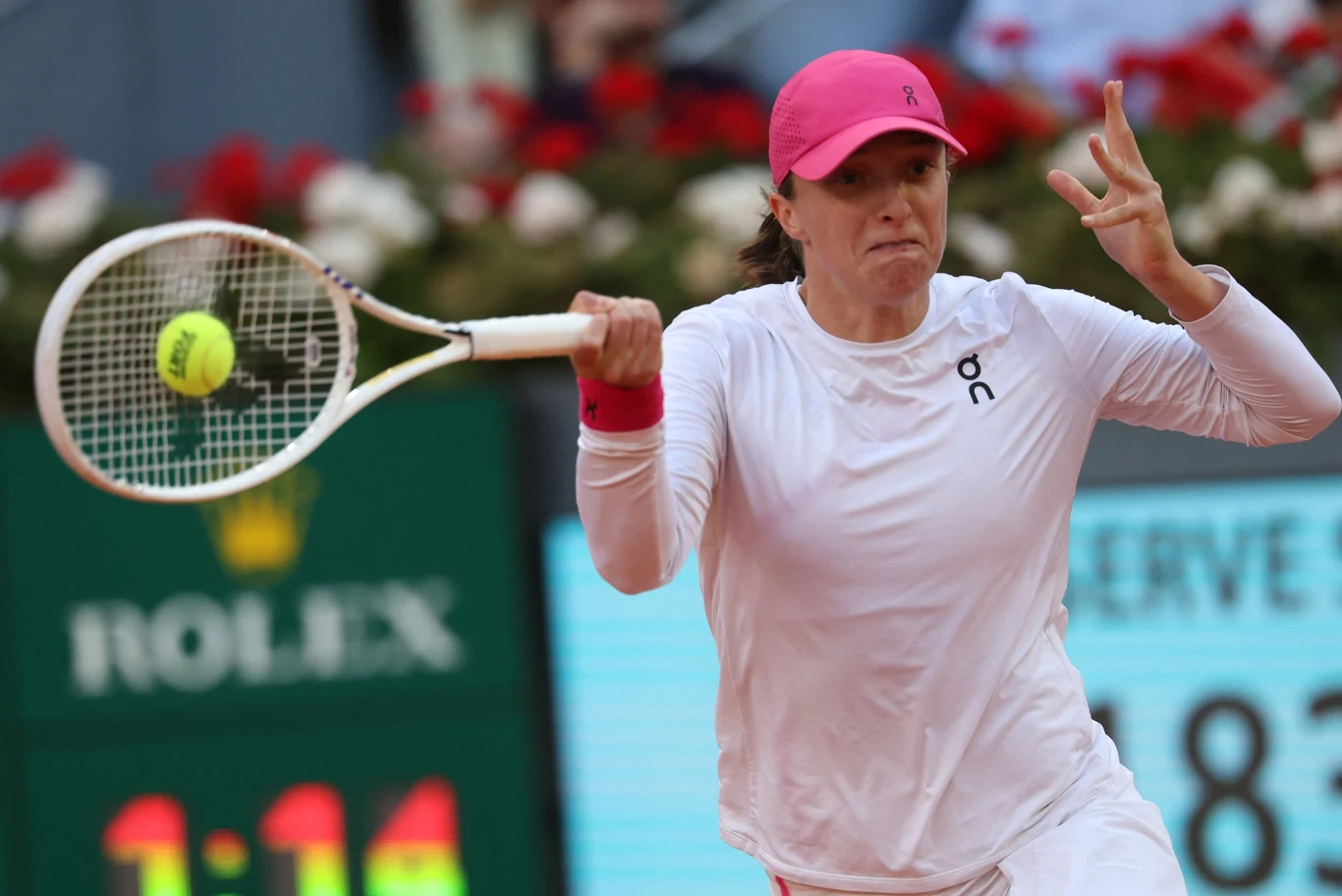 Iga Świątek, finał WTA Madryt 2024 Iga Świątek podczas finału WTA Madryt 2024 wykonuje forehand, piłka przy rakiecie, w tle tablica i reklama Rolex