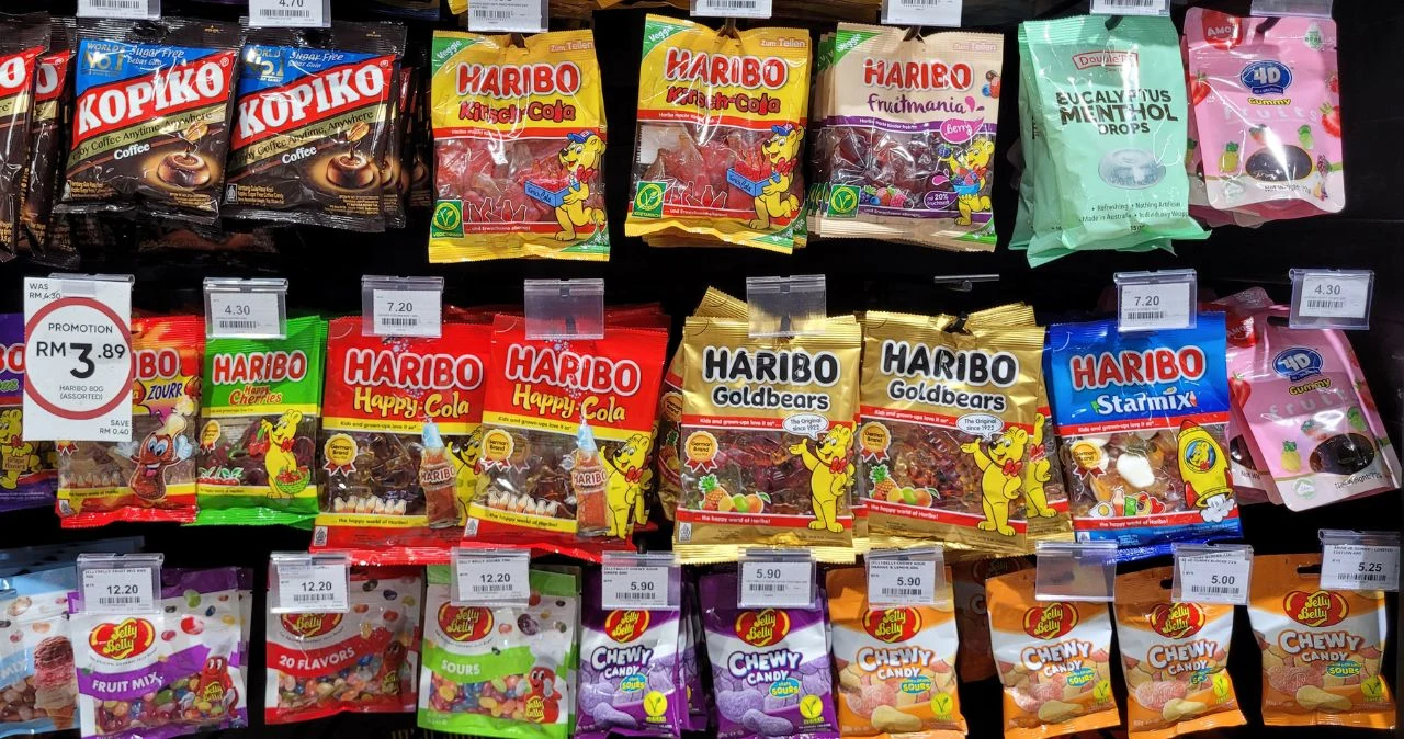 Dealz uderza w łasuchów – słodycze nawet 2+1 gratis od czwartku Półka sklepu Dealz z żelkami Haribo i innymi słodyczami w kolorowych opakowaniach, widoczne ceny pod produktami