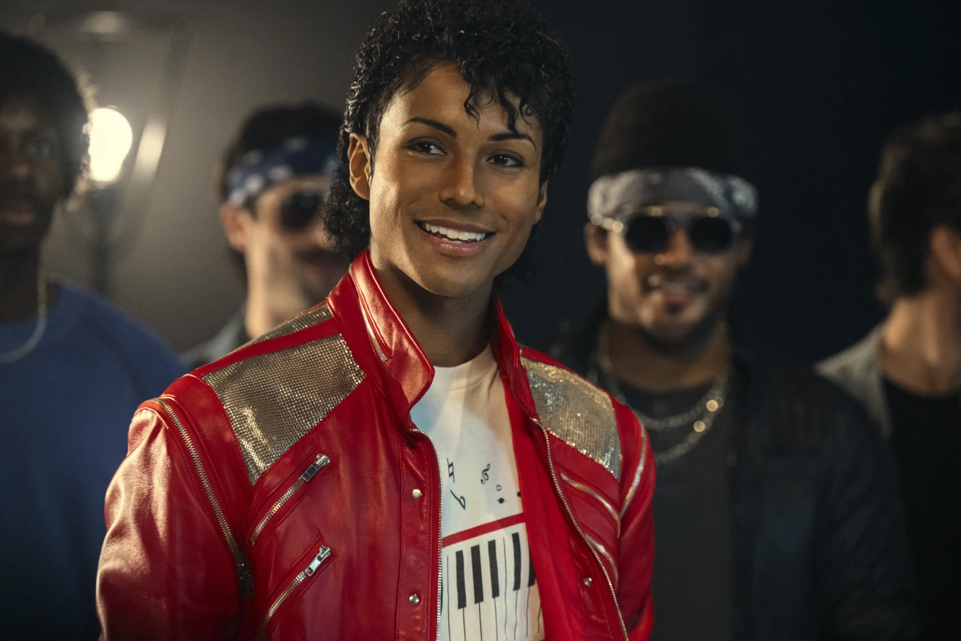 Kadr z filmu "Michael", fot. materiały dystrybutora UIP Mężczyzna w czerwonej kurtce z złotymi akcentami i białej koszulce z grafiką klawiatury. Kadr z filmu "Michael".