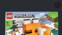 Zestaw klocków LEGO Minecraft Siedlisko Lisów przeznaczony dla dzieci od 8 lat, przedstawiający scenę z gry Minecraft z pomarańczowo-białym budynkiem przypominającym głowę lisa, figurkami postaci oraz lisów, a także elementami krajobrazu zimowego z rze...
