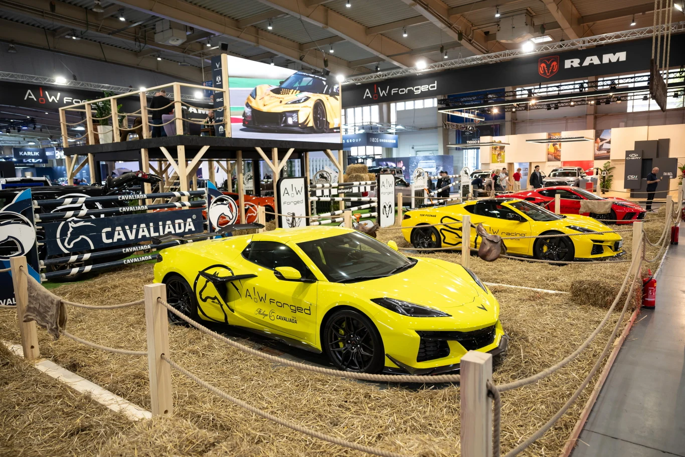 Salon Poznań Motor Show wystartował w czwartek i potrwa do niedzieli włącznie Żółty sportowy samochód AW Forged oraz drugi żółty i czerwony samochód na hali Poznań Motor Show, w tle ekspozycja.