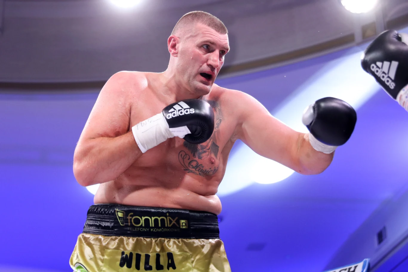 Mariusz Wach już po raz trzeci stoczy walkę dla federacji Prime Show MMA Mariusz Wach w złotych spodenkach i czarnych rękawicach na ringu podczas gali Prime MMA, widoczne tatuaże.