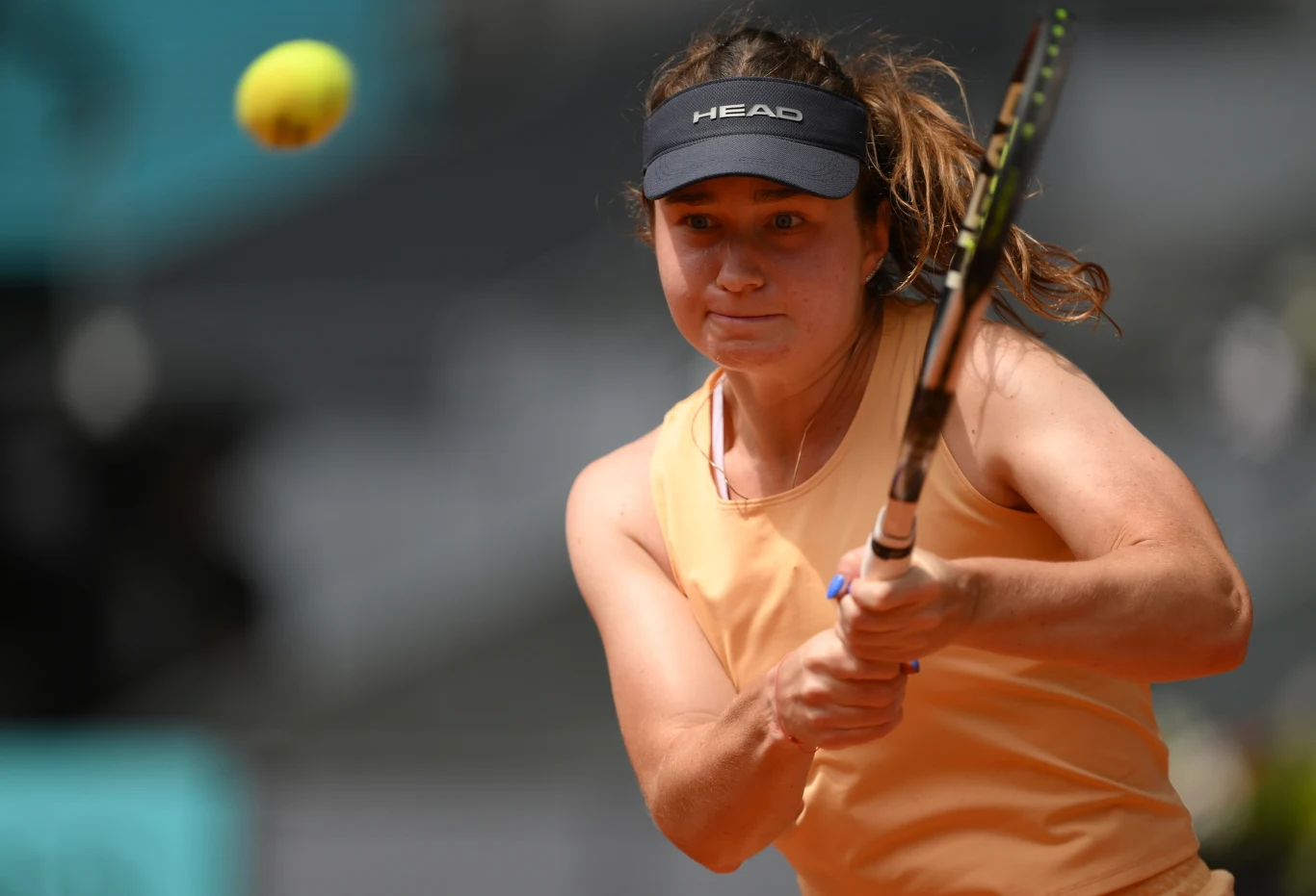 tenisistka uderzająca piłkę rakietą podczas meczu, skupienie widoczne na twarzy oraz dynamiczny ruch rąk