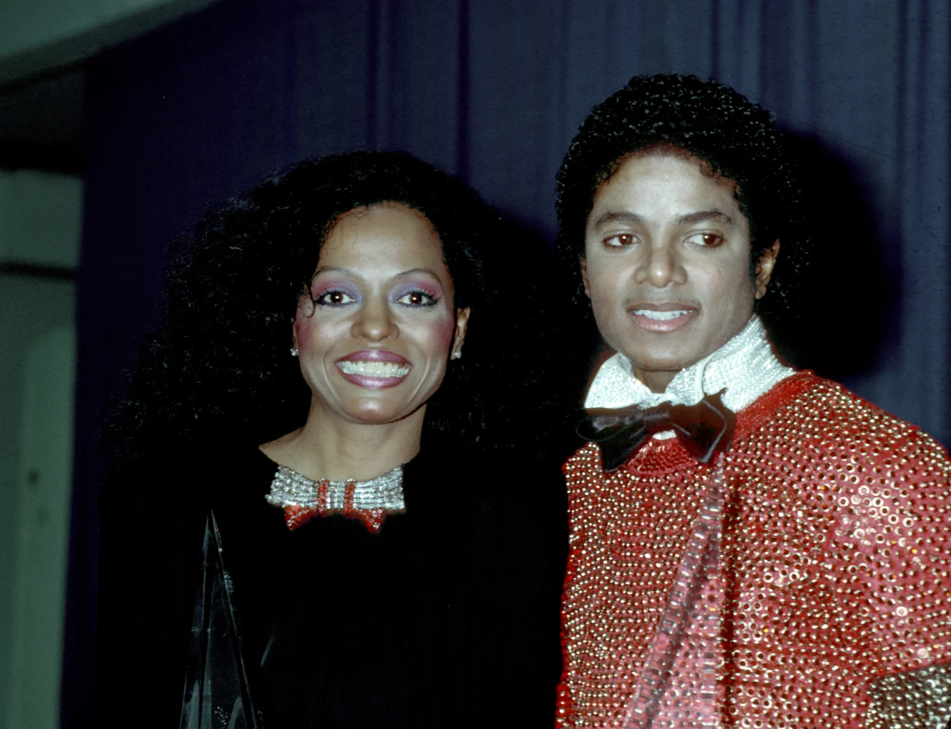 Diana Ross i Michael Jackson w 1981 r. Diana Ross i Michael Jackson w 1981 roku; eleganckie stroje na tle ciemnofioletowej zasłony.