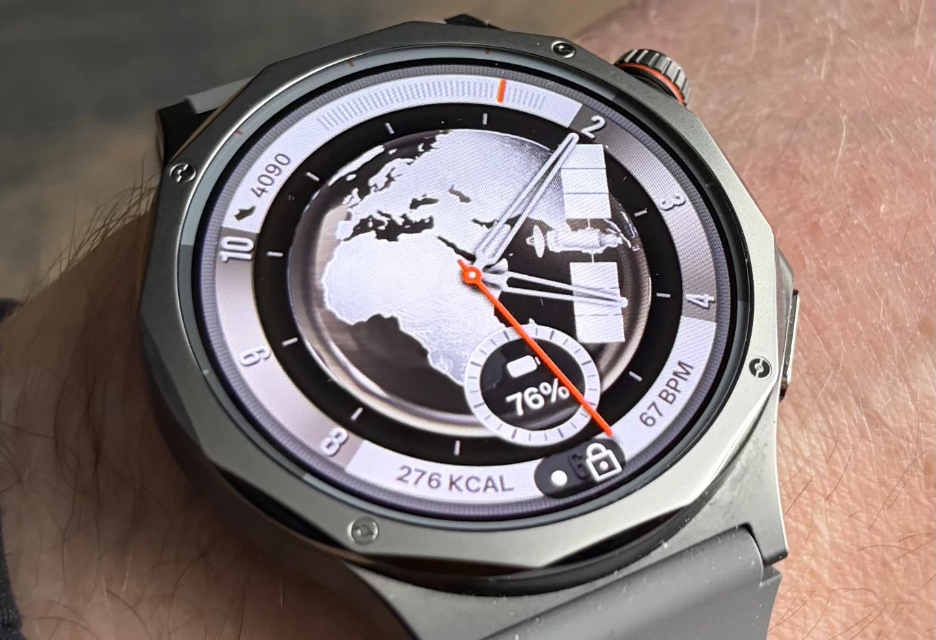 Smartwatch Oppo Watch X3 ma duży i jasny wyświetlacz. nowoczesny smartwatch na nadgarstku z tarczą wyświetlającą mapę Europy i Afryki, wskaźnikiem procentowym naładowania baterii, licznikiem spalonych kalorii oraz aktualnym tętnem