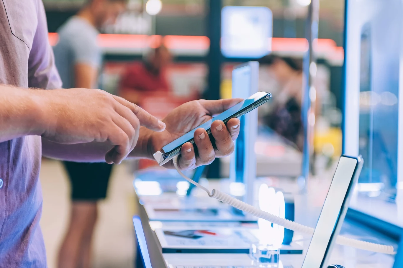Resort kultury pracuje nad nowelizacją rozporządzenia o opłacie reprograficznej Osoba testująca smartfona w sklepie elektronicznym, trzymająca urządzenie na tle innych telefonów na ladzie