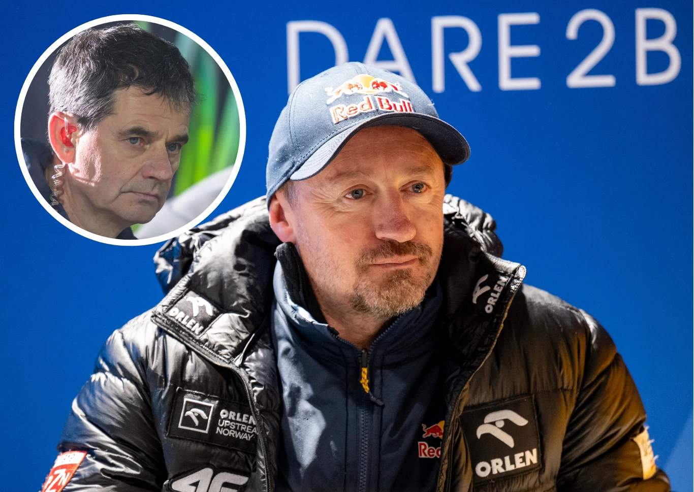 Adam Małysz i Stefan Horngacher Adam Małysz w kurtce Orlen i czapce Red Bull na tle ściany „DARE 2B”; wstawienie z portretem Stefana Horngachera.