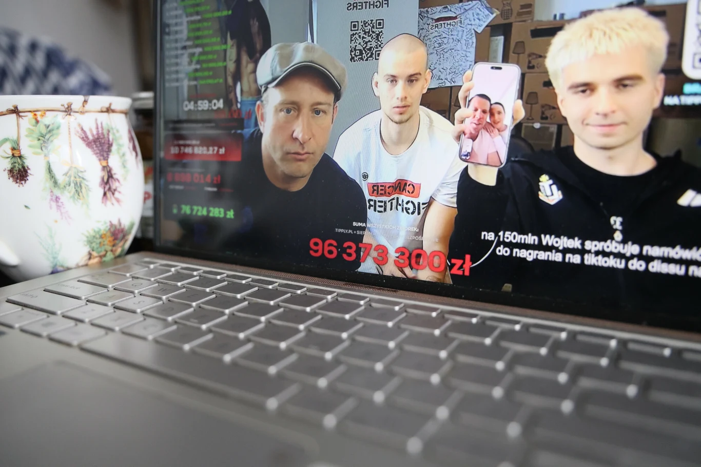 Borys Szyc, Łatwogang i Mata podczas połączenia z Wojciechem Szczęsnym i Mariną podczas streamu live Borys Szyc, Łatwogang i Mata podczas wideokonferencji na streamie z widocznym czatem i sumą pieniędzy na ekranie