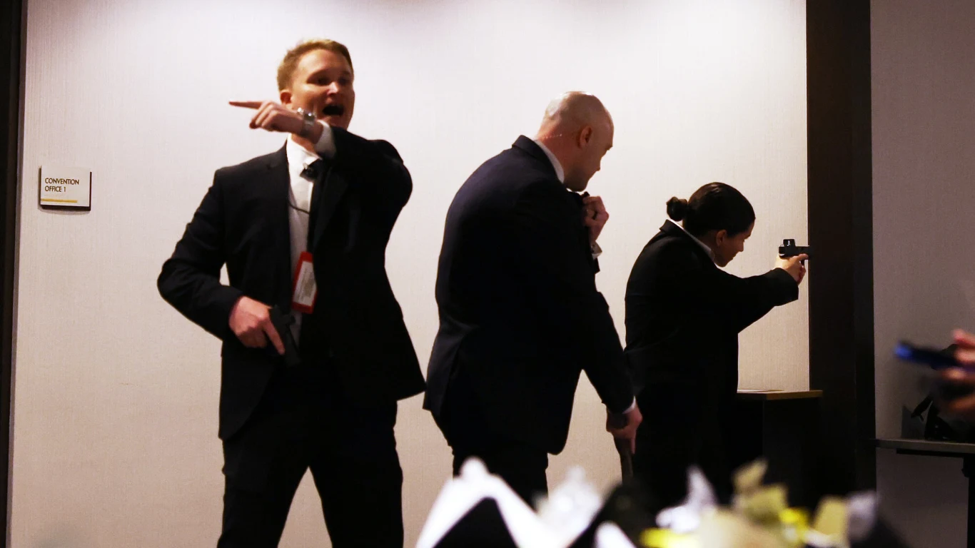 Agenci Secret Service po strzelaninie w pobliżu w hotelu Hilton Trzej agenci Secret Service w garniturach z bronią, zabezpieczają teren wewnątrz budynku.