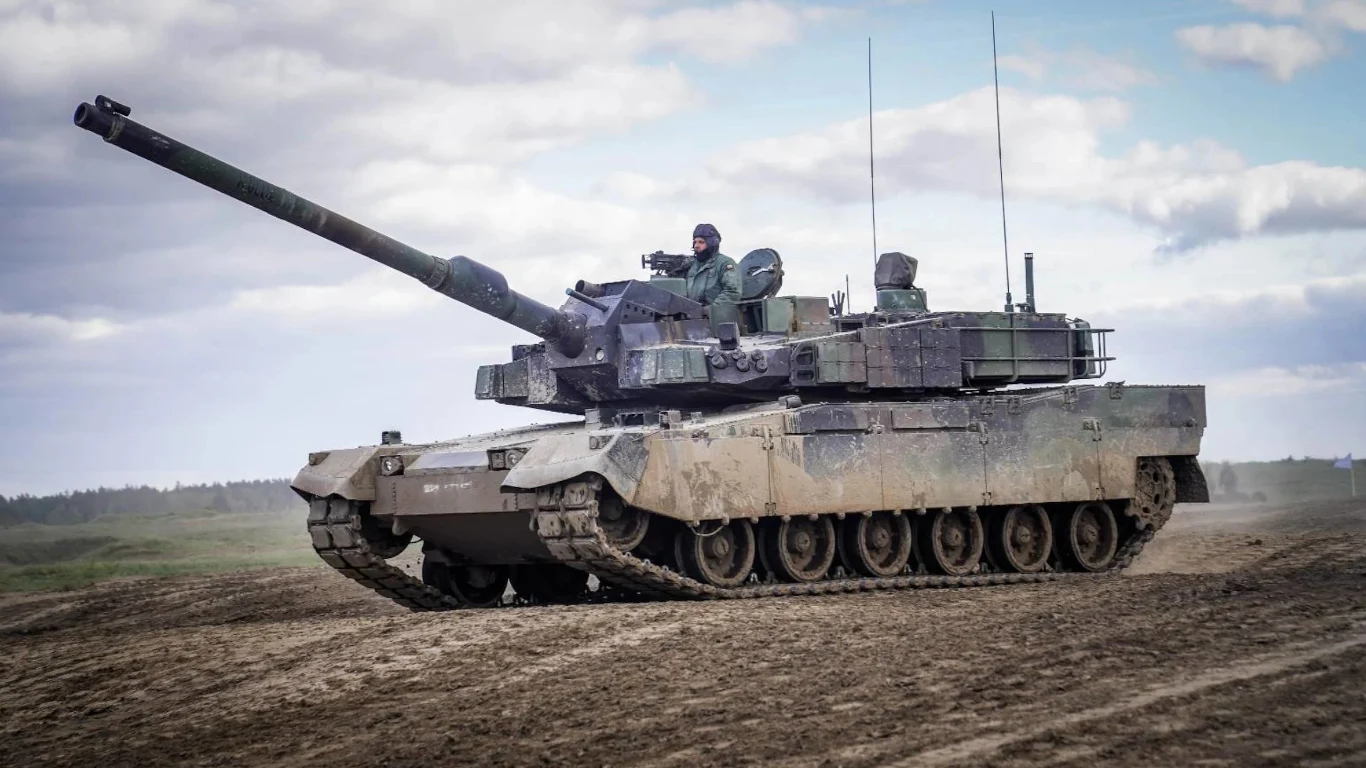 Polska wraca do produkcji nowoczesnych czołgów. Ważne umowy podpisane Nowoczesny czołg K2 Black Panther na poligonie, przemieszczający się po piaszczystym terenie z jednym żołnierzem widocznym w wieżyczce; w tle niebo z chmurami i rozległy krajobraz.