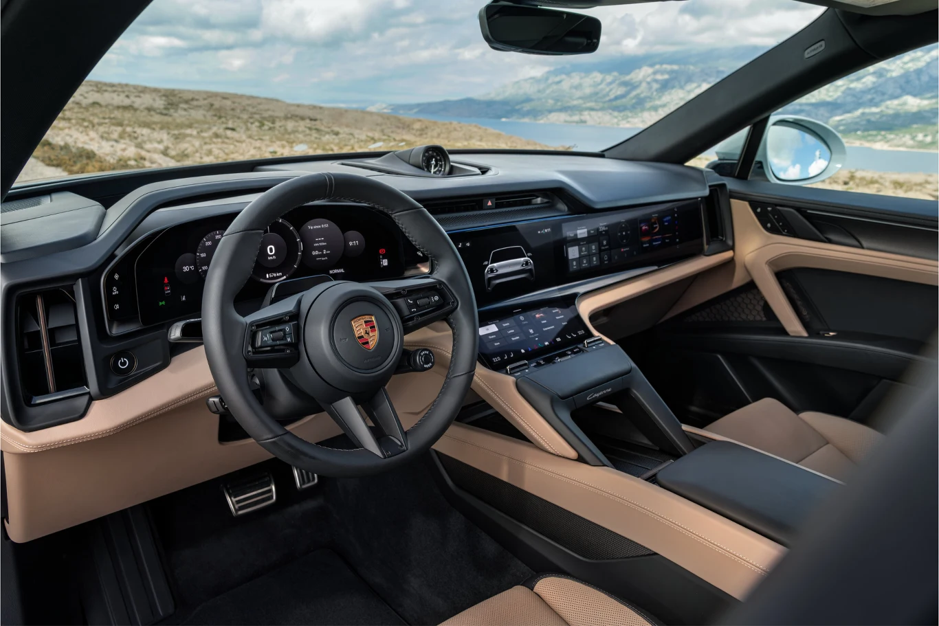 kokpit nowoczesnego samochodu marki Porsche z cyfrowym zestawem wskaźników, wielofunkcyjną kierownicą i rozbudowanym panelem multimedialnym w otoczeniu beżowo-czarnych materiałów wykończeniowych