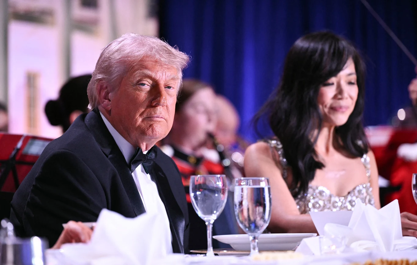 Posiłki po kolacji dziennikarzy z Donaldem Trumpem rozdane schroniskom Donald Trump w smokingu i kobieta w sukni przy stole na gali kolacji dziennikarzy w hotelu Hilton